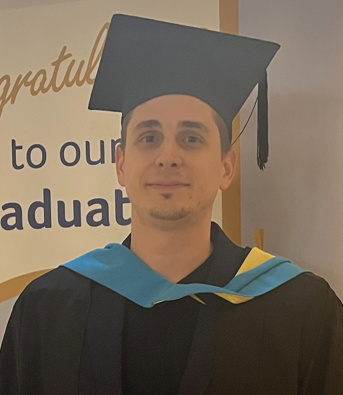 Headshot of Stefano in his graduation gown and hat.