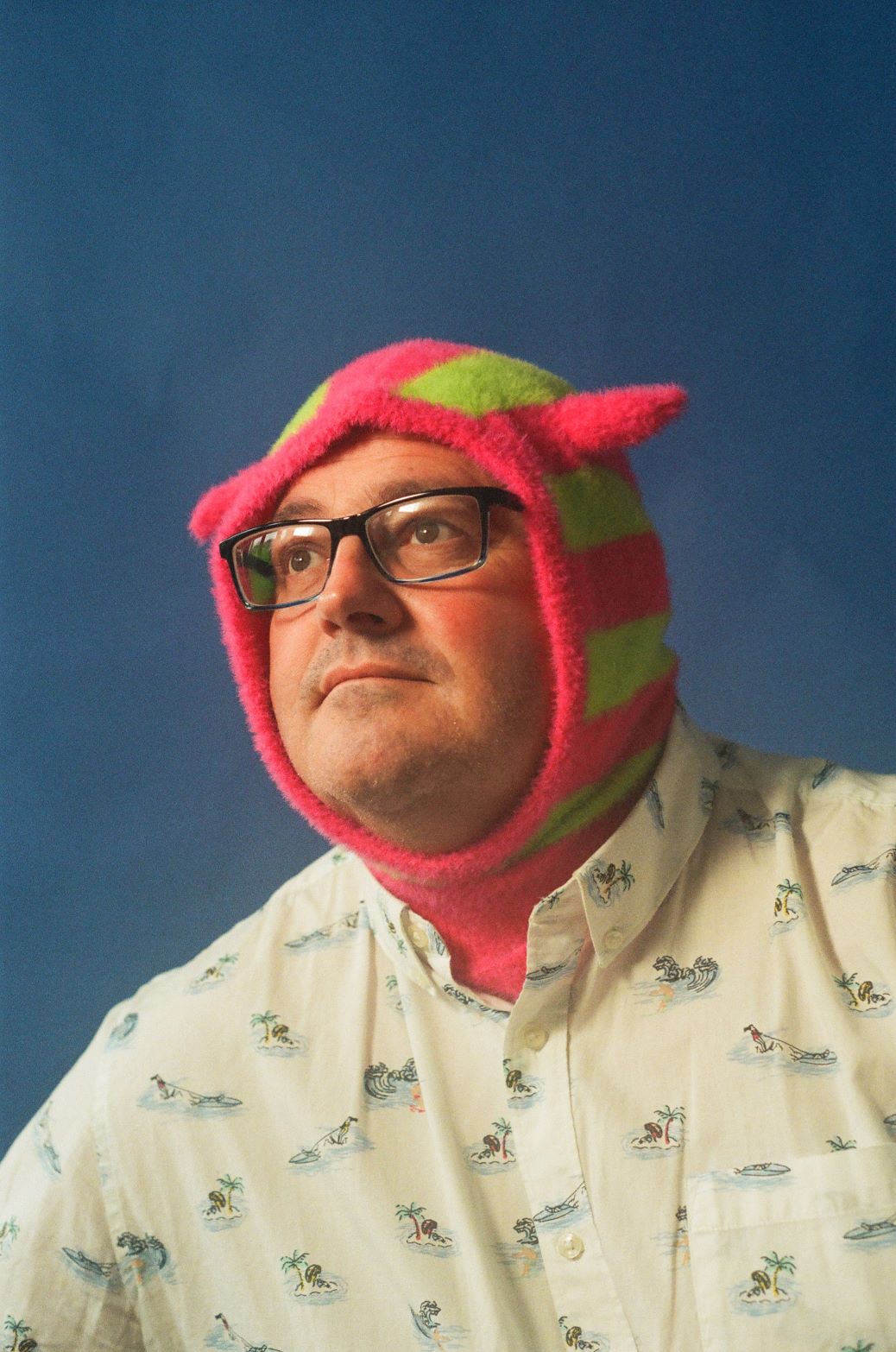 Man with a pink and green hat on